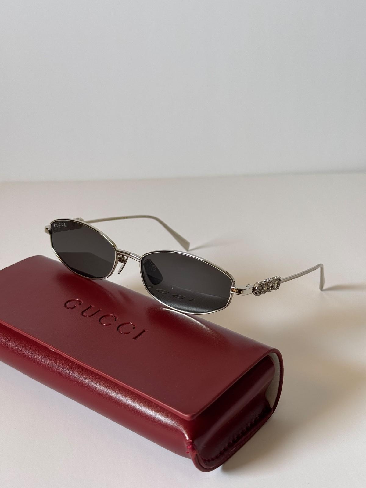 Gucci oval metal sunglasses with crystal GUCCI wordmark temples · 2